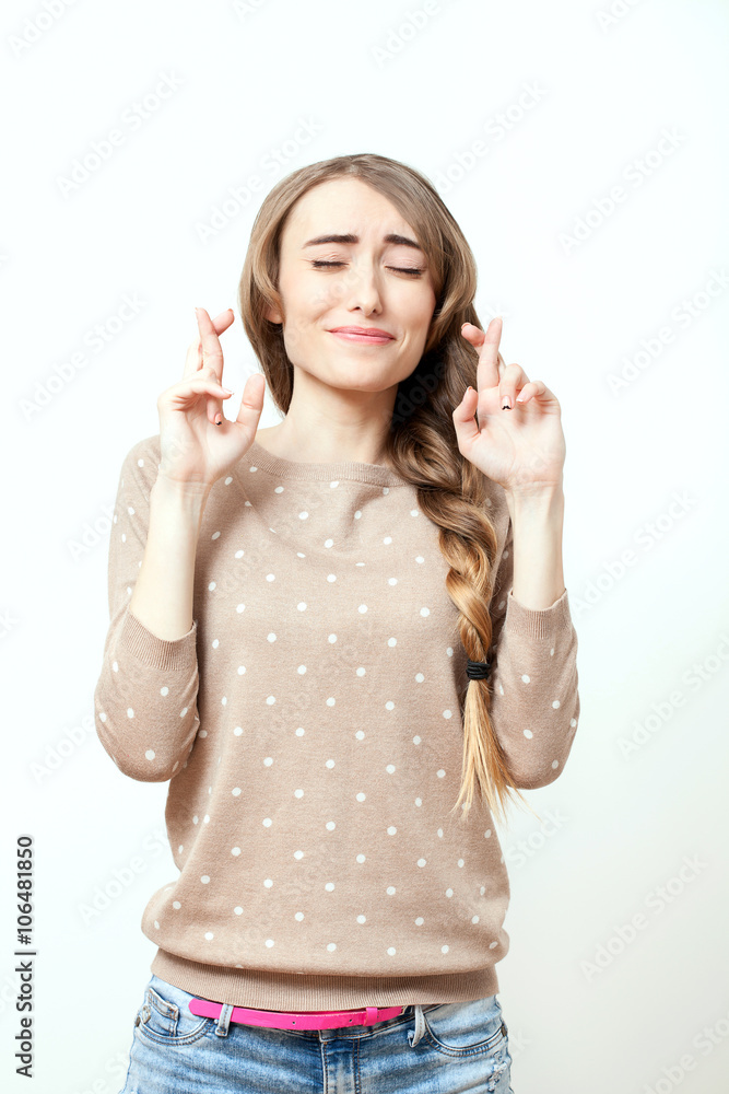 Beautiful girl making a wish. Woman in stylish clothes to makeup and hairstyle in studio on white background. Bright positive emotions of young woman. Beautiful girl making a wish. Woman in stylish clothes to makeup and hairstyle in studio on white background. Bright positive emotions of young woman.