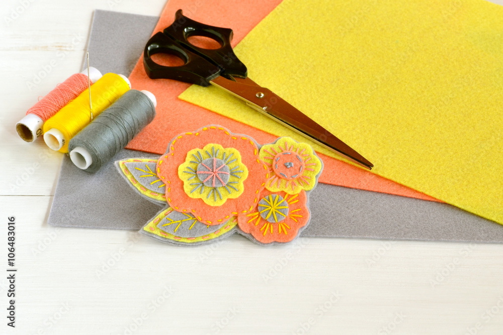 Fototapeta premium Floral felt brooch, handmade crafts. Felt sheets, scissors, thread, needle - sewing set