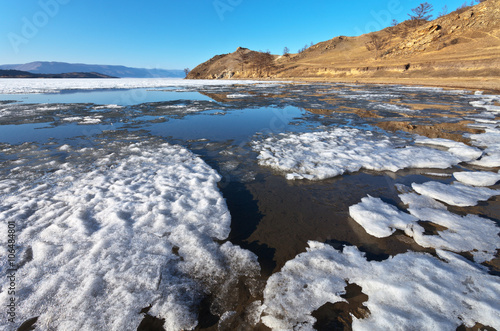 Fototapeta Naklejka Na Ścianę i Meble -  Baikal Lake. Sunny spring day. The ice floes are melting on a sandy beach