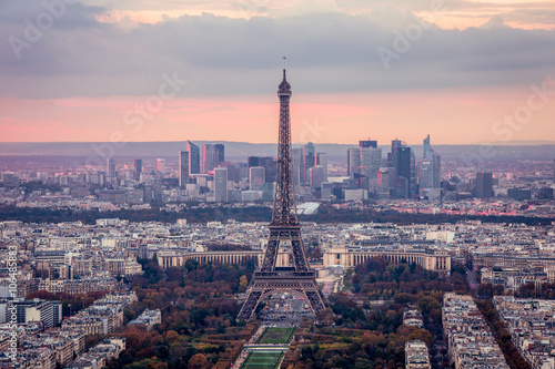 A panorama of Paris at a sunset. A view of the Eiffel Tower, the Defence quarter, of the urban neighborhoods from the bird's-eye view. The sky is clouded over. © illyabel