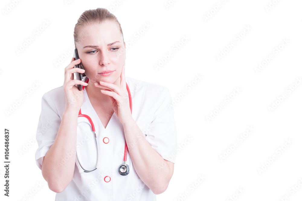 Female doctor talking on the phone and thinking Female doctor talking on the phone and thinking
