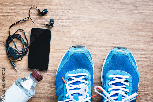 Flat lay shot of Sport equipment, shoes, water, earphone and pho