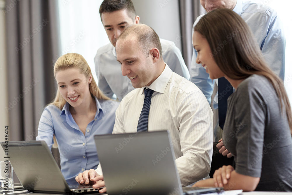 smiling businesspeople with laptops in office smiling businesspeople with laptops in office