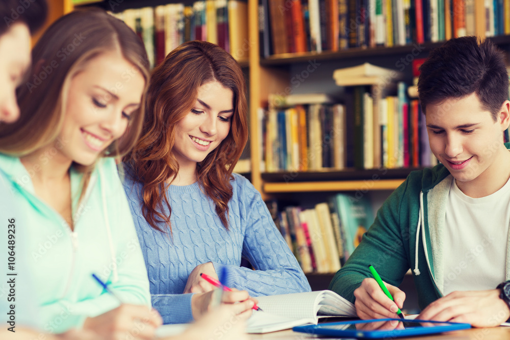 happy students writing to notebooks in library happy students writing to notebooks in library