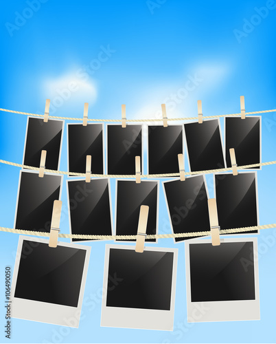 Photo frames hanging on clothesline with clothespins on blue sky