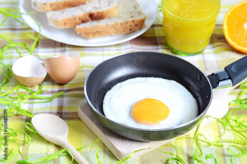 Fried egg, toast bread, fresh juice and oranges