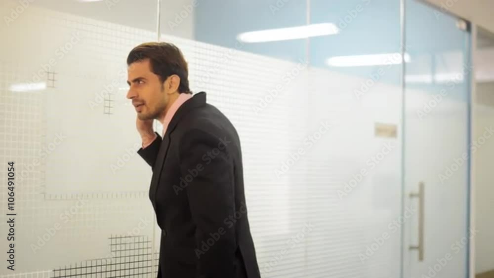 Locked-on shot of a businessman by window try to listen Locked-on shot of a businessman by window try to listen