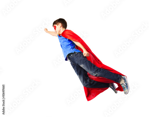 boy in red superhero cape and mask flying on air