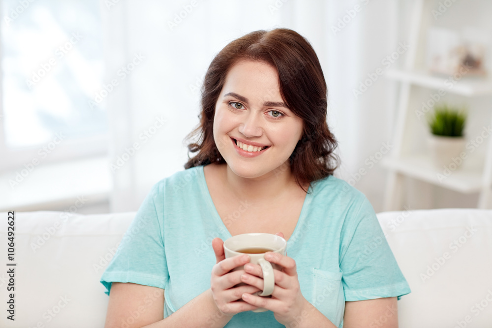 happy plus size woman with cup of tea at home