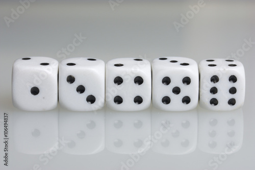 Dice. Playing cubes. Throwing the dice during the game. White cubes arranged in a row. On a white background. There is room for text.