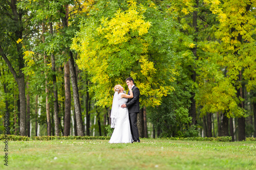 Beautiful Romantic Wedding Couple  Kissing and Embracing Outdoors