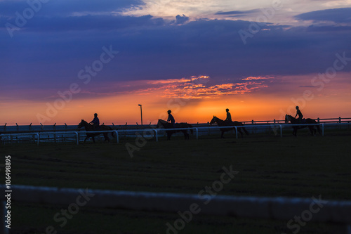 Horses Riders Dawn Sunrise training track silhouetted.