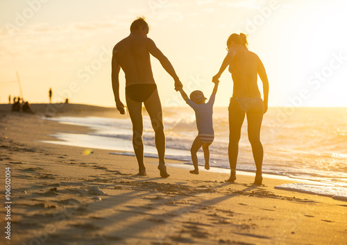 Happy family with little boy together at sunset
