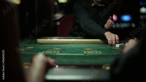 Dealer shuffling playing cards on a poker table in a casino
