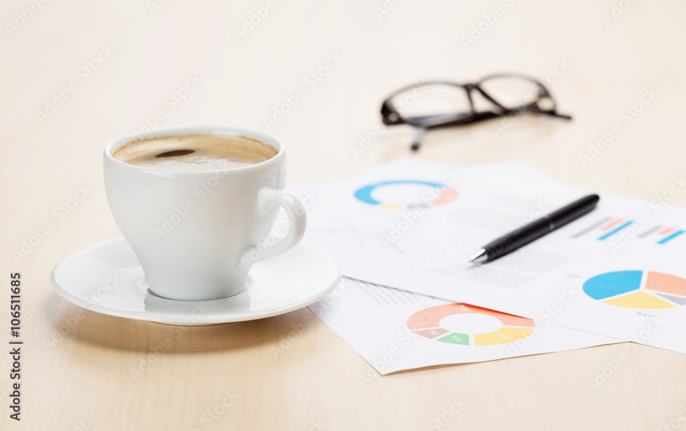 Office workplace with coffee cup and charts Office workplace with coffee cup and charts
