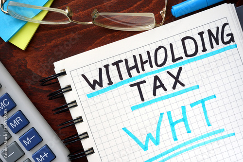 Whithholding tax WHT concept  written in a notebook on a wooden table. photo