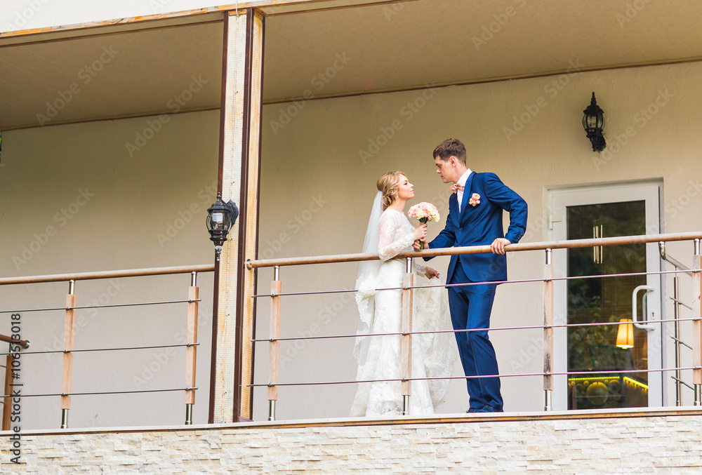 the bride and groom on a balcony