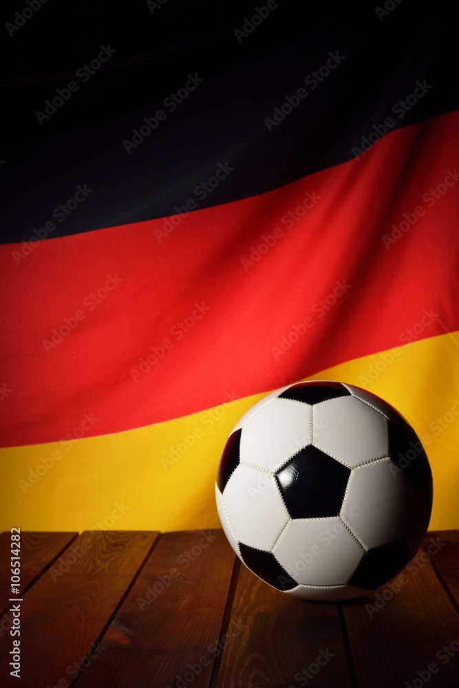 Flag of Germany with football on wooden boards as the background. Flag of Germany with football on wooden boards as the background.