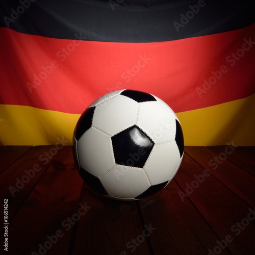 Flag of Germany with football on wooden boards as the background.