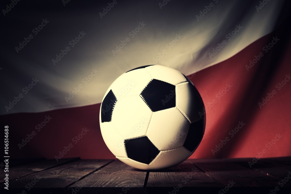 Flag of Poland with football on wooden boards as the background. Vintage Style.