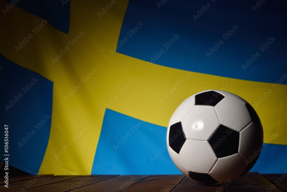 Fototapeta premium Flag of Sweden with football on wooden boards as the background.