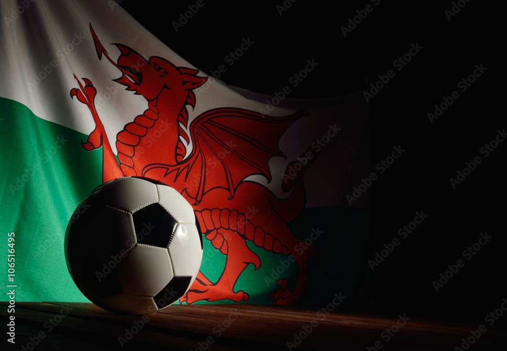 Flag of Wales with football on wooden boards as the background.