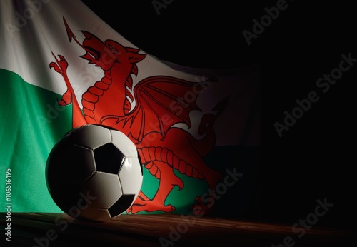 Flag of Wales with football on wooden boards as the background.