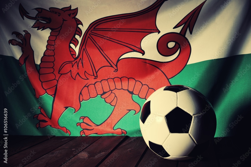 Flag of Wales with football on wooden boards as the background. Vintage style.
