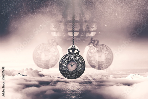 Hypnotising watch on a chain swinging above clouds photo