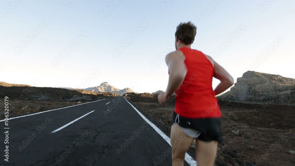 Runner man running on road training for marathon run. Sporty fit caucasian male fitness sport model working out outside in mountain nature volcano landscape. Runner man running on road training for marathon run. Sporty fit caucasian male fitness sport model working out outside in mountain nature volcano landscape.