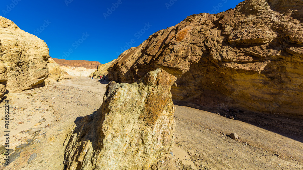 Narrow canyon with vertical walls on both sides. Rocky landscape background. Sandstone formations in Golden canyon, Death Valley Narrow canyon with vertical walls on both sides. Rocky landscape background. Sandstone formations in Golden canyon, Death Valley