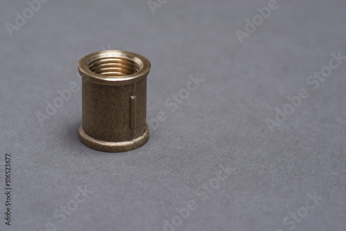 Brass plumbing fitting on grey table