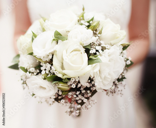 Bride holding bouquet of white roses