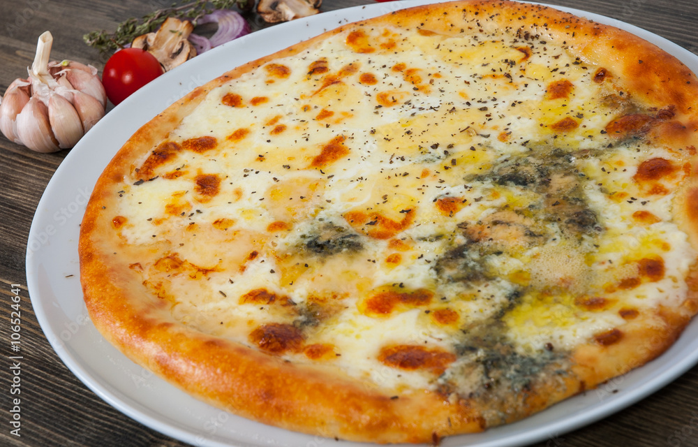 pizza quatrro fromaggi (four cheese) on a wooden table pizza quatrro fromaggi (four cheese) on a wooden table