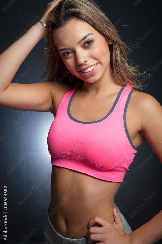 Attractive female fitness model isolated on a black background Attractive female fitness model isolated on a black background