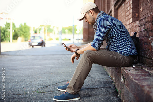 Young businessman professional on smartphone walking in street using app texting sms message on smartphone  © opolja