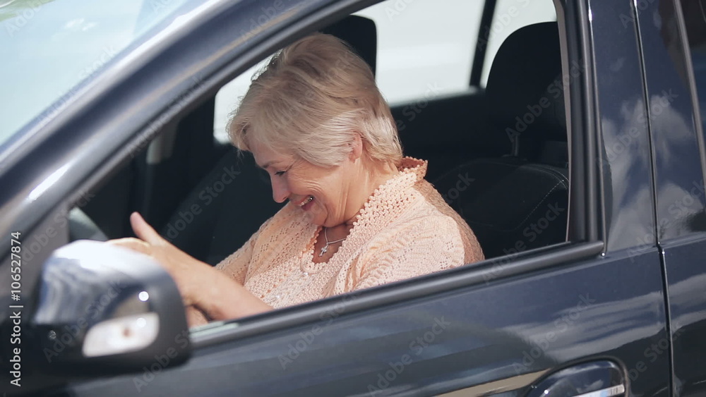 New Car: Senior attractive woman win or buy a new modern car and joy