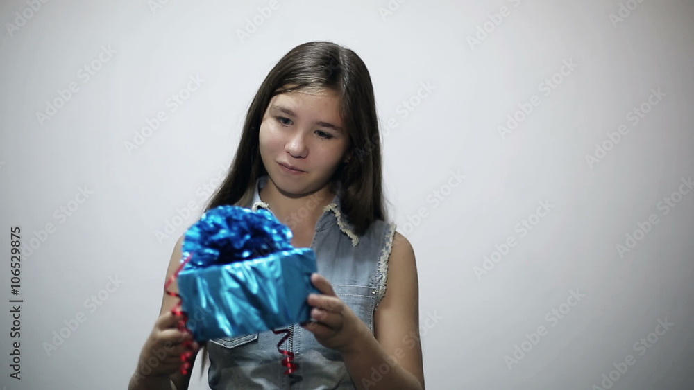 Receiving a Gift: Attractive teenager girl expresses the joy of receiving a gift isolated on gray studio background Receiving a Gift: Attractive teenager girl expresses the joy of receiving a gift isolated on gray studio background