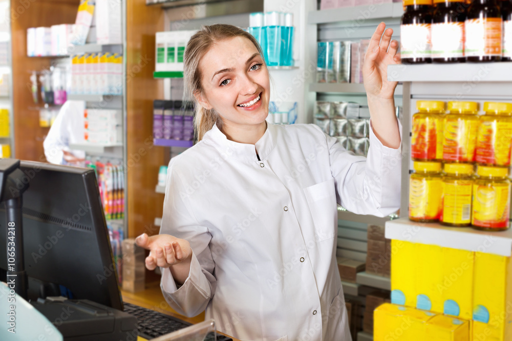 Smiling positive young female pharmacist posing