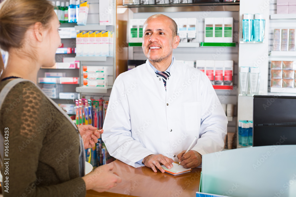 Pharmacist serving client in pharmacy .