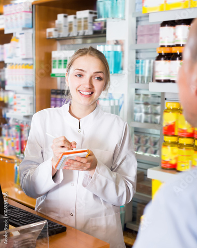 Pharmaceutist helping man in drugstore