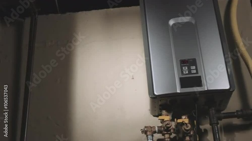 camera moves right on a tankless water heater in the basement of a residential home