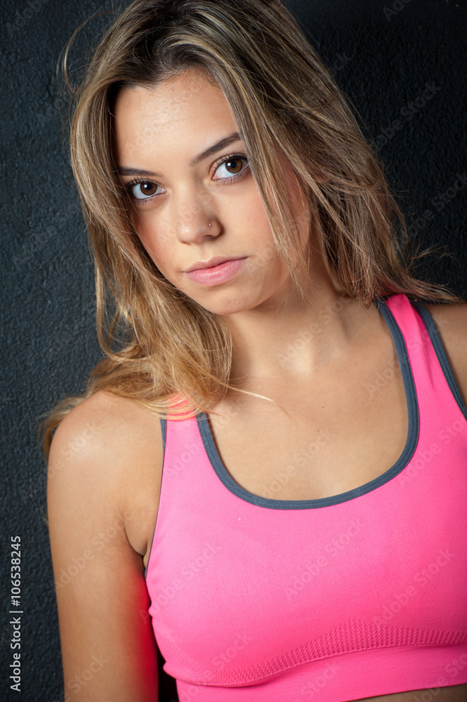 Fototapeta premium Attractive female fitness model isolated on a black background