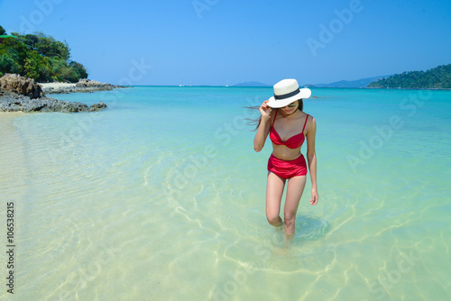 Young pretty woman walking on the beach