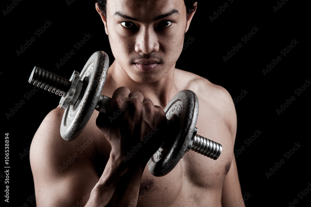 Muscular Asian man with dumbbell
