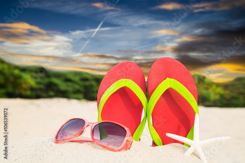 Colorful sandals and sunglases on beach ready for summer holiday