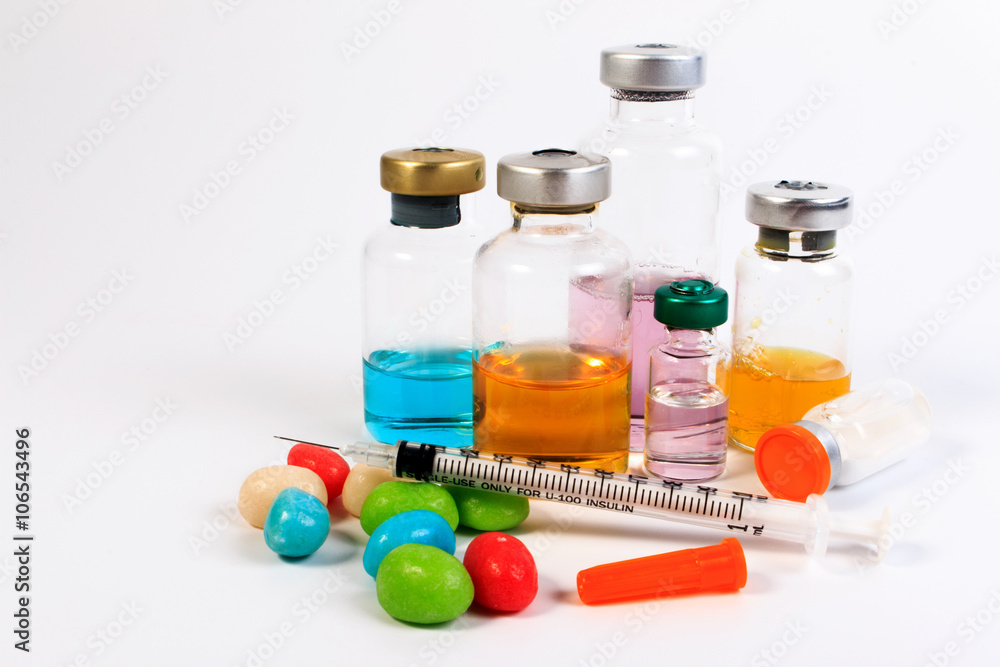 A syringe and candy bottle isolate on white background. Protect against diabetes. A syringe and candy bottle isolate on white background. Protect against diabetes.