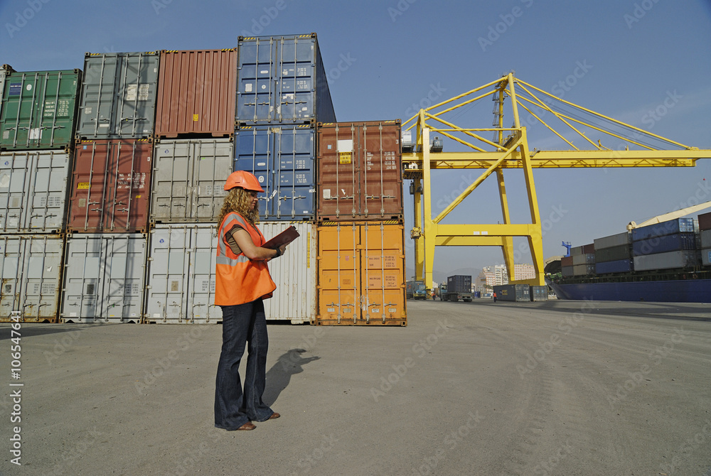 Female worker with clipboard in cargo container terminal Female worker with clipboard in cargo container terminal