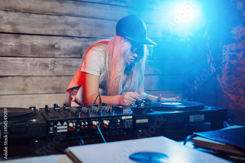 Cute dj woman having fun playing music at club party