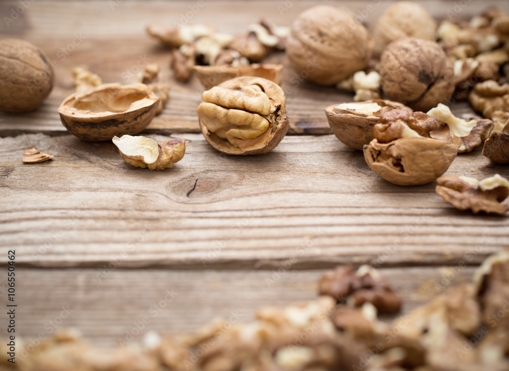 Walnut kernels and whole walnuts on rustic old wooden table Walnut kernels and whole walnuts on rustic old wooden table